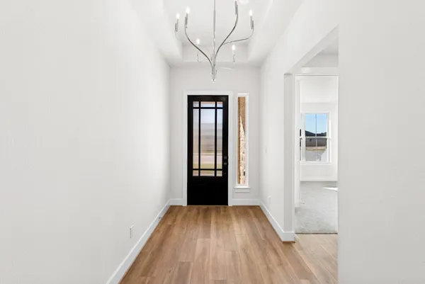 a view of a hallway with wooden floor and closet