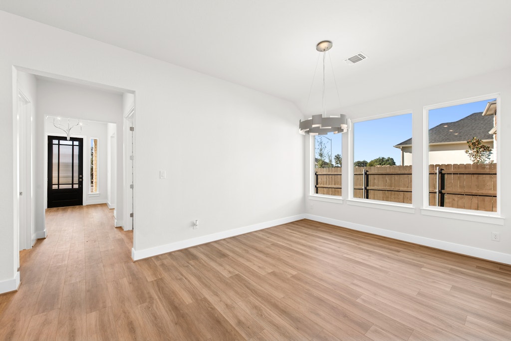 3332 Emerald Lake Path Georgetown, TX 78628 - Photo 9 of 35 a view of an empty room with a window and wooden floor