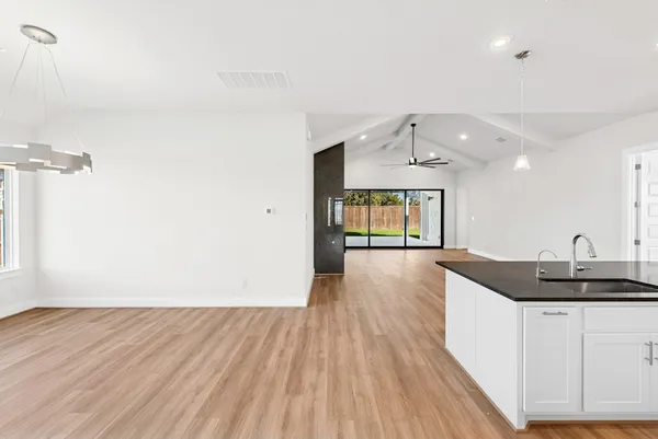 a kitchen with a sink and wooden floor