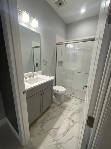 a bathroom with a sink a toilet and shower