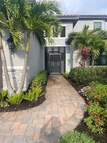 a front view of a house with a yard and a garden
