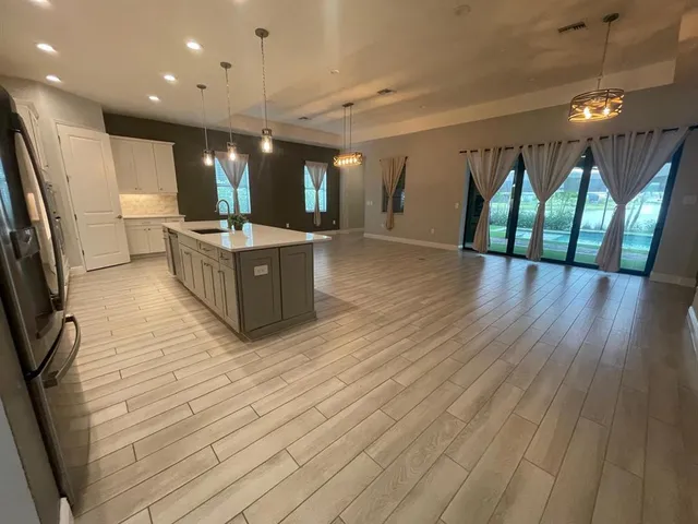 a large space with lots of wooden furniture and stainless steel appliances