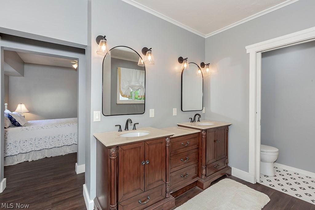 3090 Warren Road Cleveland, OH 44111 - Photo 20 of 50 Bathroom with dual vanity, ornamental molding, toilet, and hardwood / wood-style floors