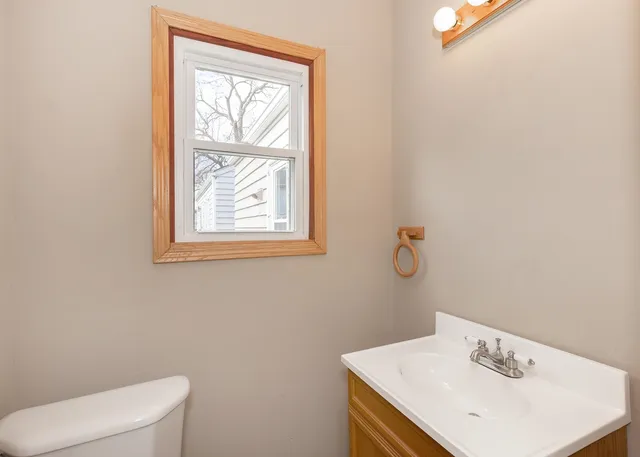 a bathroom with a sink a toilet and a window