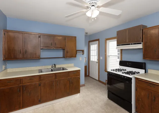 a kitchen with stainless steel appliances a sink cabinets and wooden floor