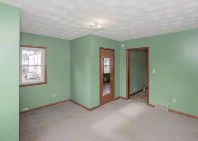 an empty room with closet and windows