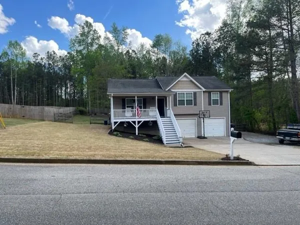 a view of a house with a patio and a yard