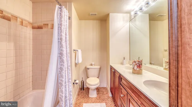 a bathroom with a sink a toilet and shower curtain