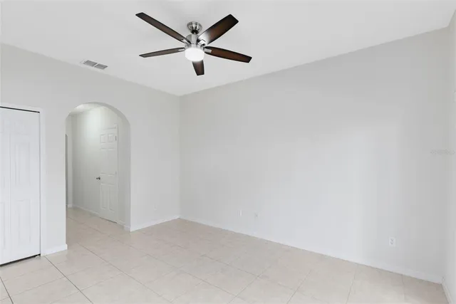 an empty room with a ceiling fan and a fan