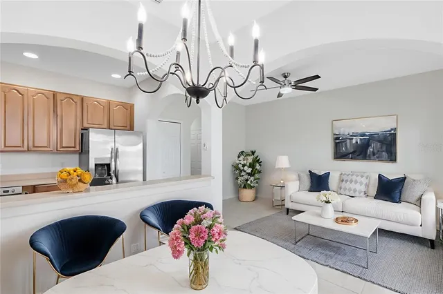 a living room with furniture kitchen view and a chandelier