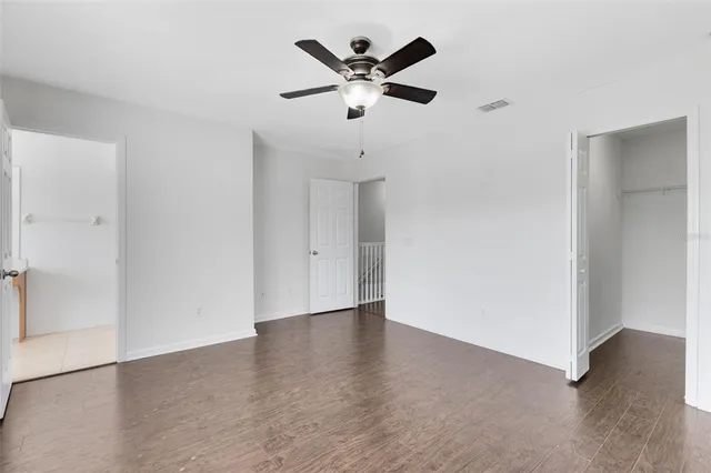 an empty room with closet and ceiling fan