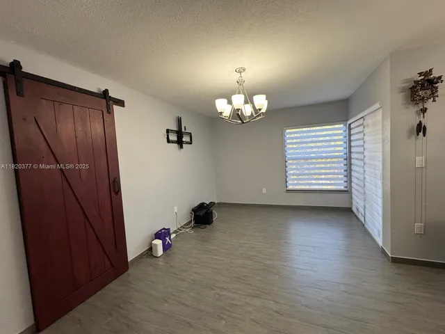 an empty room with wooden floor and window