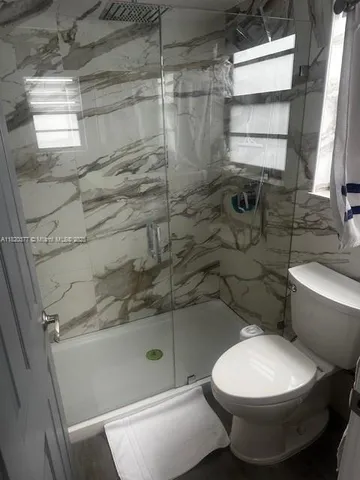 a bathroom with a toilet and a shower