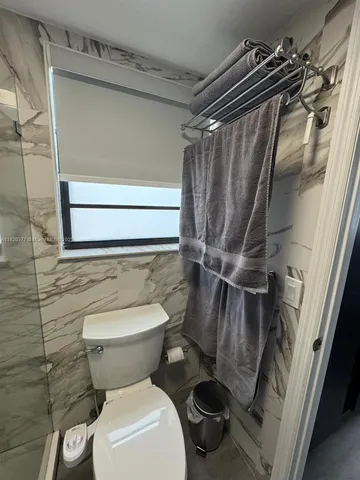 a bathroom with a toilet and a shower