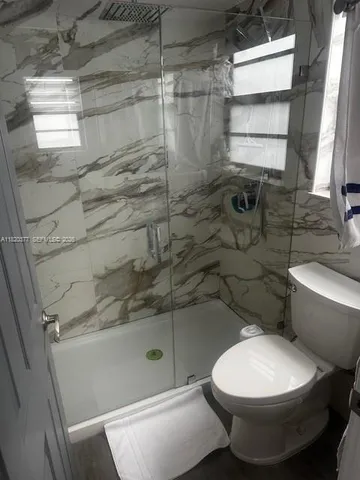 a bathroom with a toilet and shower