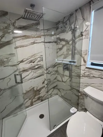 a bathroom with a toilet and shower