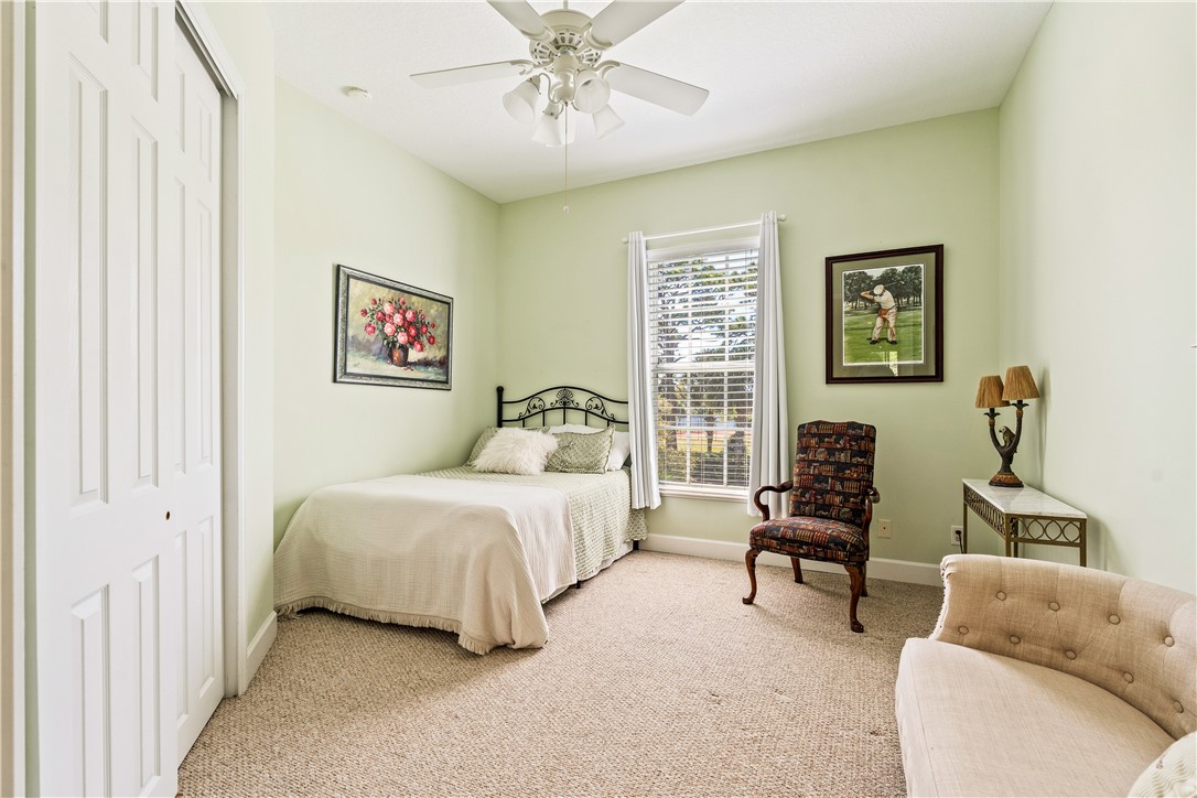 2340 Water Oak Court Southwest, Unit 223 Vero Beach, FL 32962 - Photo 27 of 36 a bedroom with a bed and a couch