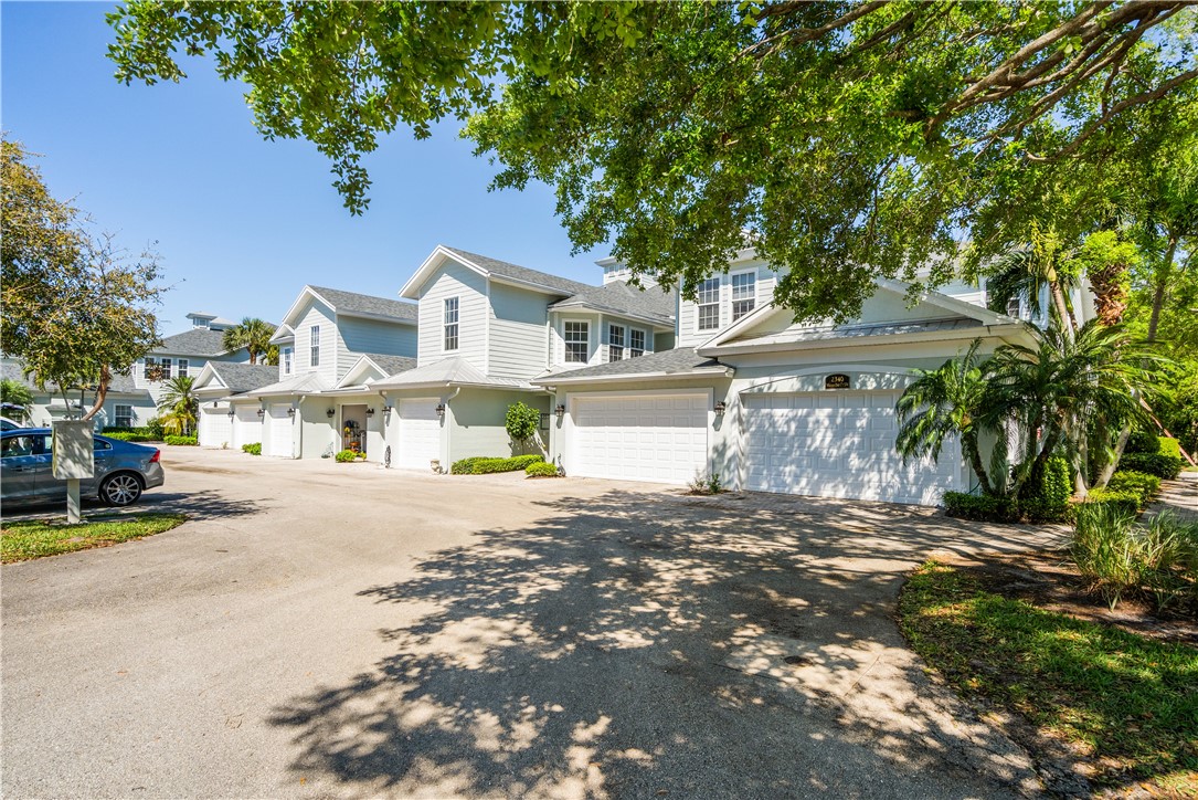 2340 Water Oak Court Southwest, Unit 223 Vero Beach, FL 32962 - Photo 29 of 36 a front view of a house with a yard and garage