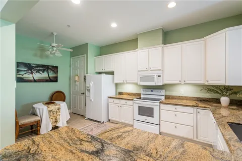 a kitchen with granite countertop cabinets a sink stainless steel appliances and cabinets