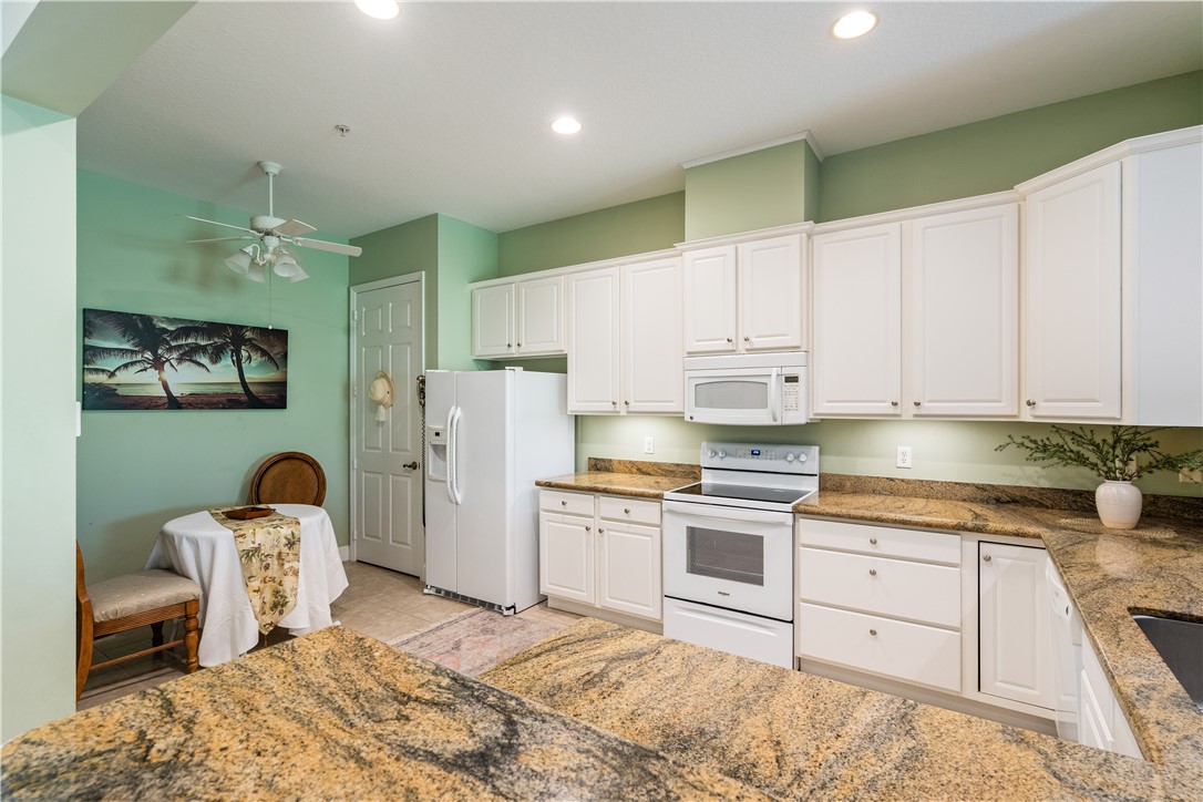 2340 Water Oak Court Southwest, Unit 223 Vero Beach, FL 32962 - Photo 3 of 36 a kitchen with granite countertop cabinets a sink stainless steel appliances and cabinets