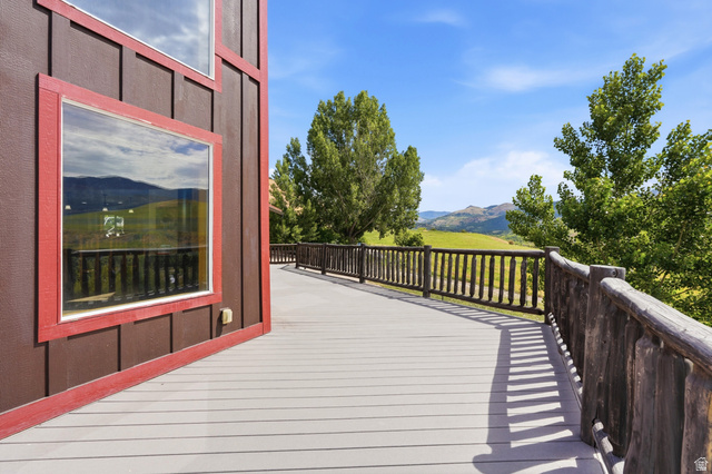 306 Spring Road Preston, ID 83263 - Photo 51 of 55 Expansive outdoor deck featuring wood-finish flooring, a rustic wood railing, and a brown vertical siding exterior with red trim