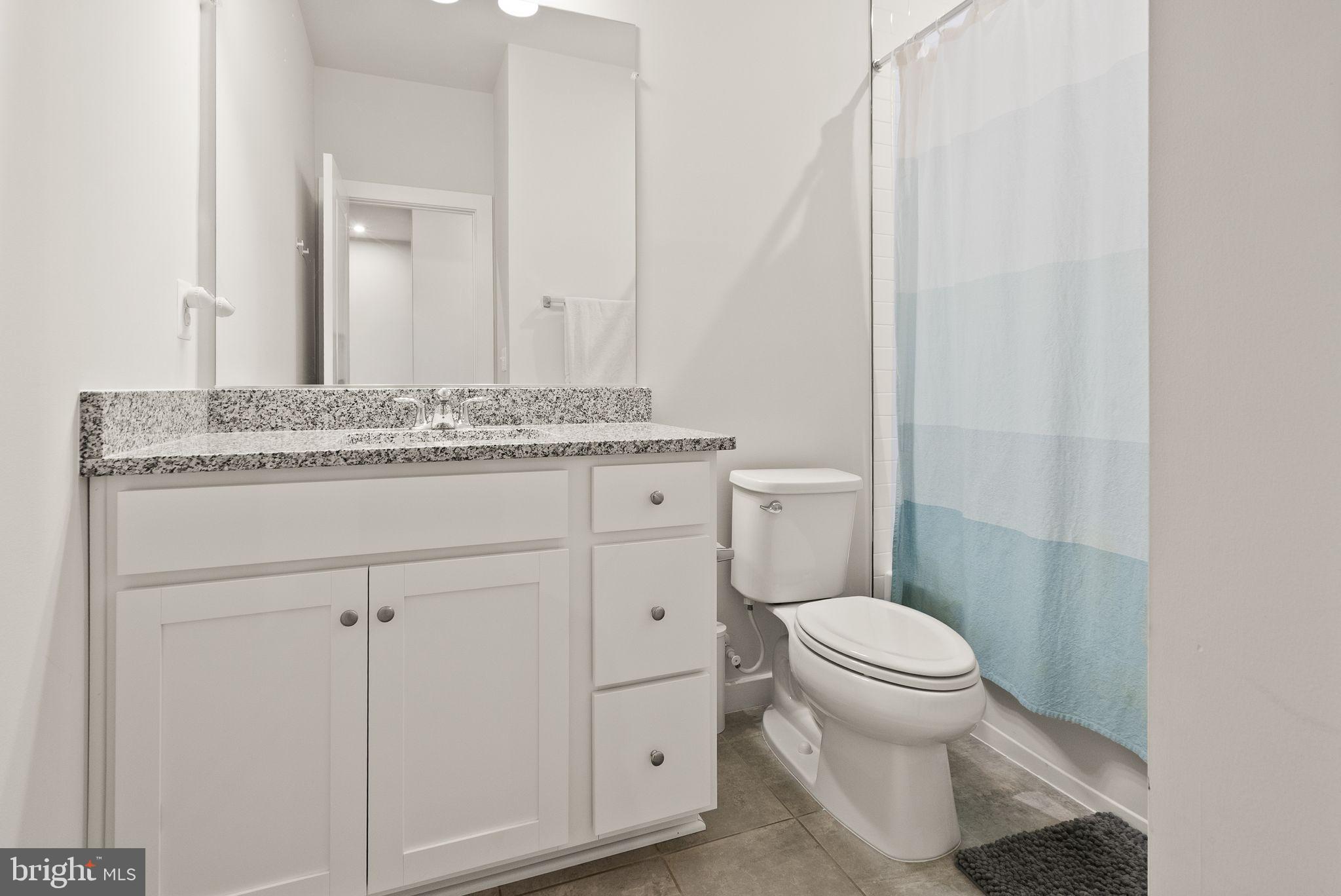 18353 Moss Garden Road Dumfries, VA 22026 - Photo 32 of 79 a bathroom with a granite countertop toilet sink and mirror