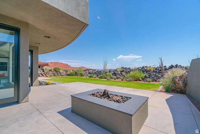 1500 Split Rock, Unit 150 Ivins, UT 84738 - Photo 3 of 18 Expansive patio featuring a built-in fire pit with decorative rocks, concrete surfacing, and direct access to the interior via large glass doors
