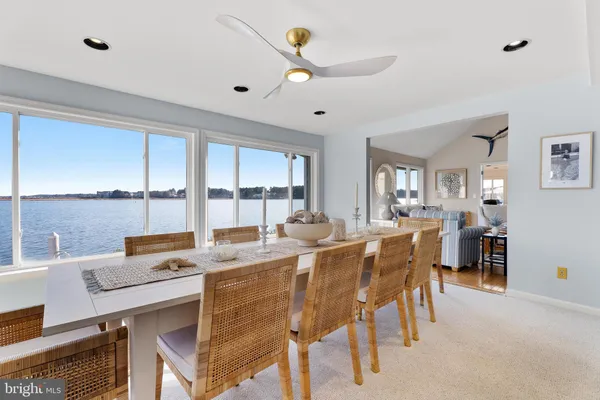 a kitchen with granite countertop a refrigerator a sink a stove and white cabinets with wooden floor