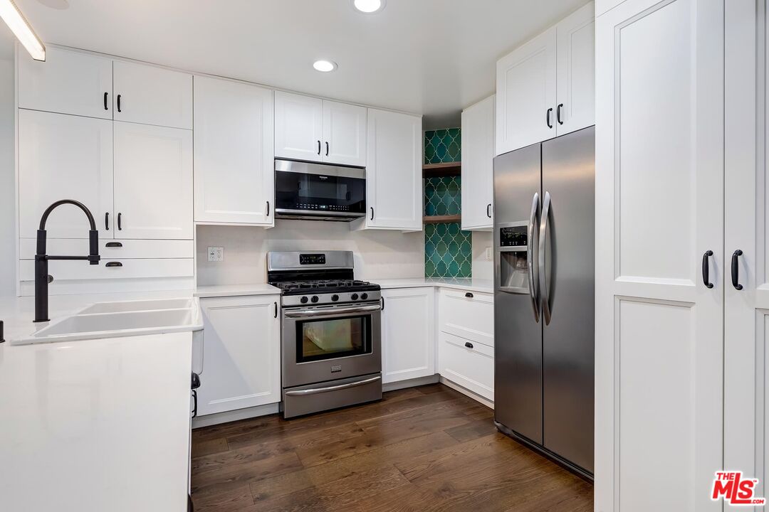 10926 Bluffside Drive, Unit 20 Studio City, CA 91604 - Photo 11 of 31 a kitchen with stainless steel appliances granite countertop a refrigerator a stove a sink and a microwave