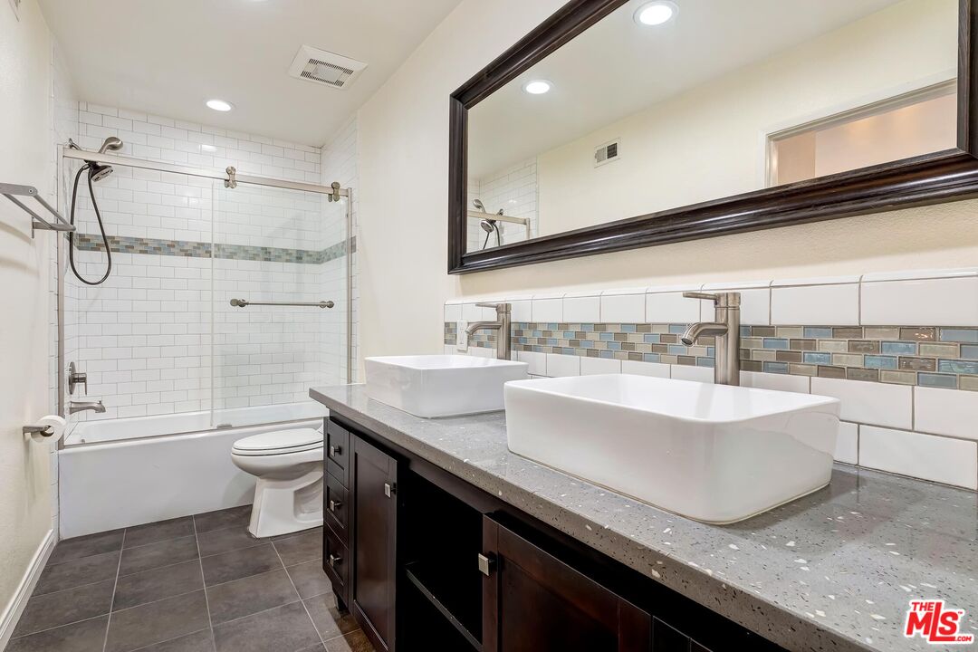 10926 Bluffside Drive, Unit 20 Studio City, CA 91604 - Photo 19 of 31 a bathroom with a granite countertop bathtub sink vanity mirror and toilet