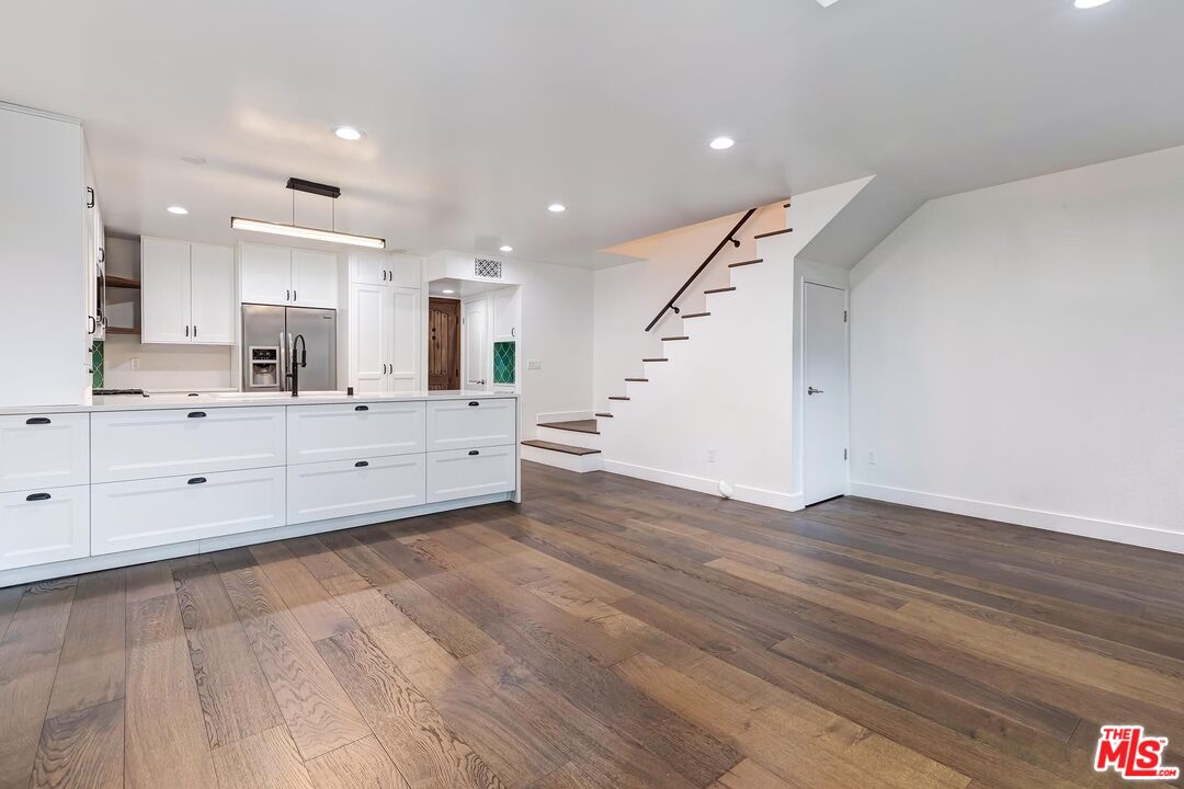 10926 Bluffside Drive, Unit 20 Studio City, CA 91604 - Photo 2 of 31 a large white kitchen with kitchen island sink and wooden floor