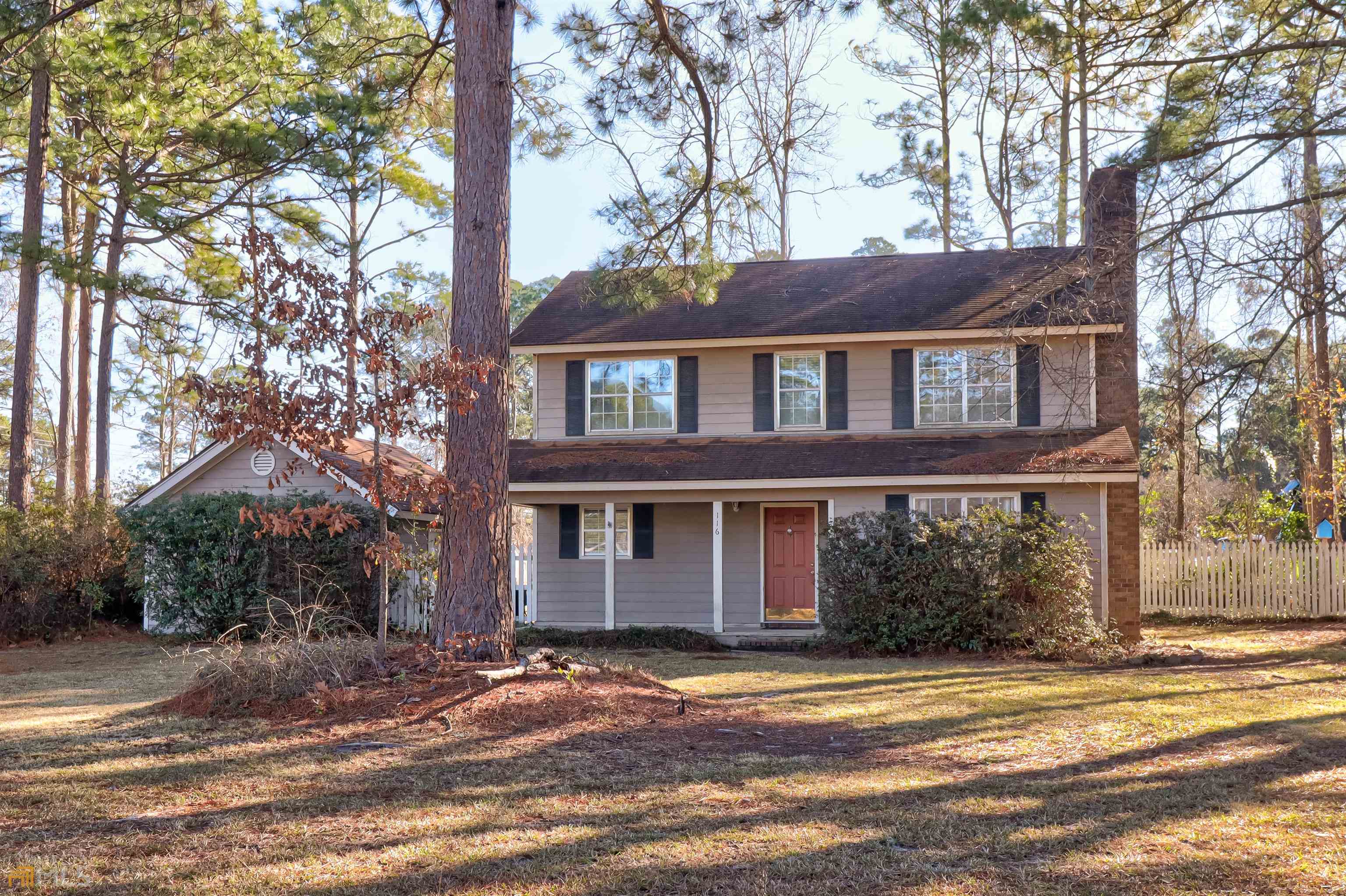 a view of a house with a yard and large tree