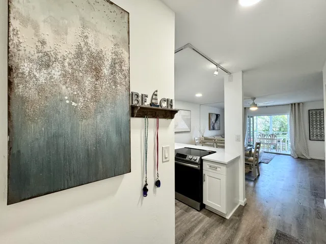 a kitchen with stainless steel appliances a refrigerator a stove a sink dishwasher and a dining table with wooden floor