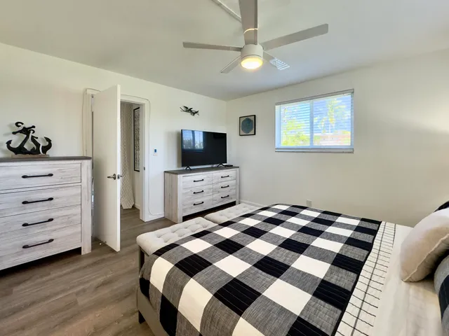 a bedroom with a bed and a tv on the dresser