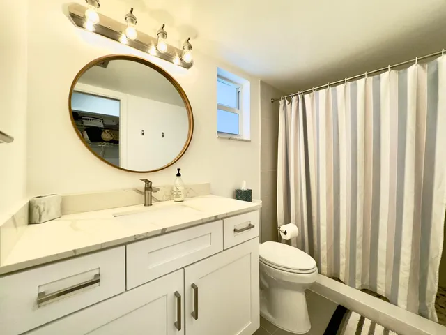 a bathroom with a toilet a sink and a mirror