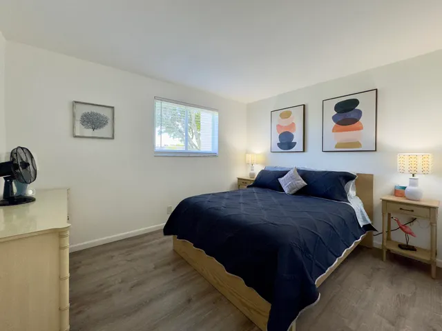 a bed room with a bed and painting on the wall