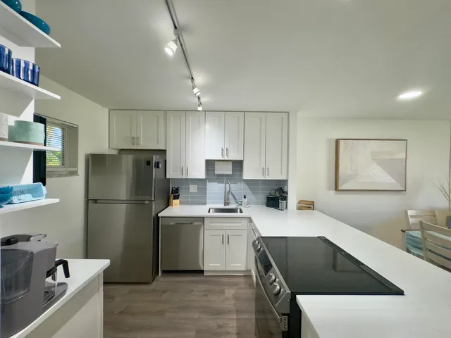a kitchen with a sink a refrigerator and a stove top oven