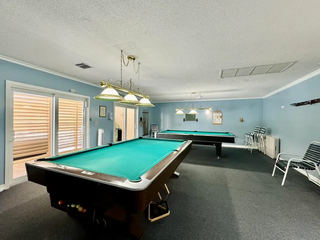 a room with furniture pool table and windows