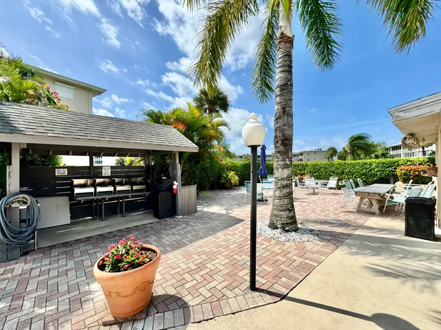 a view of a patio with table and chairs potted plants