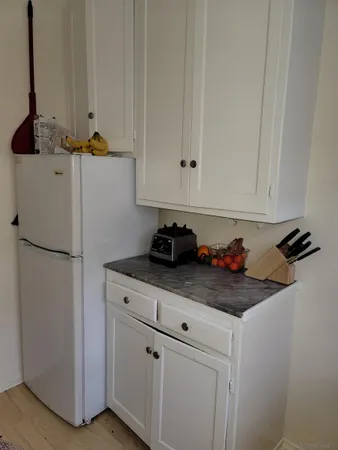 a room with stainless steel appliances white cabinets and a refrigerator