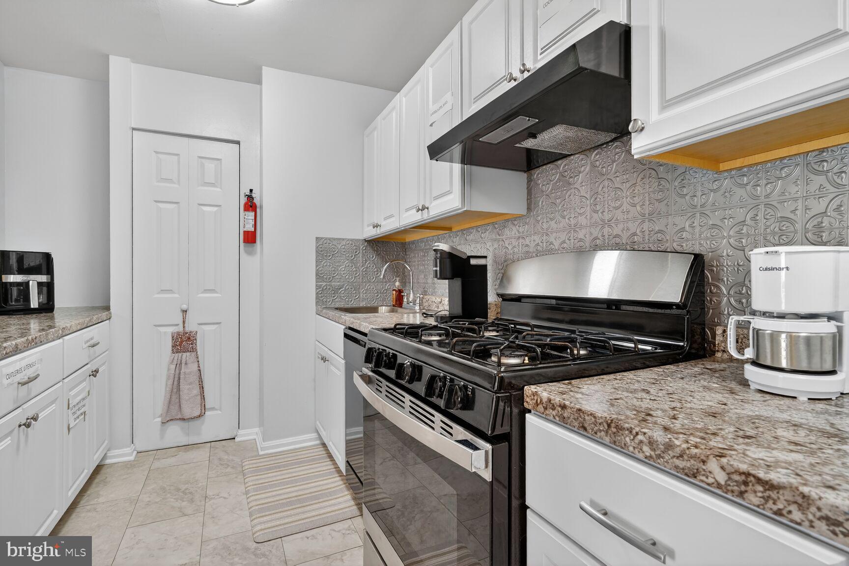 3850 Bel Pre Road, Unit 38504 Silver Spring, MD 20906 - Photo 11 of 15 a kitchen with stainless steel appliances granite countertop a stove and a wooden cabinets