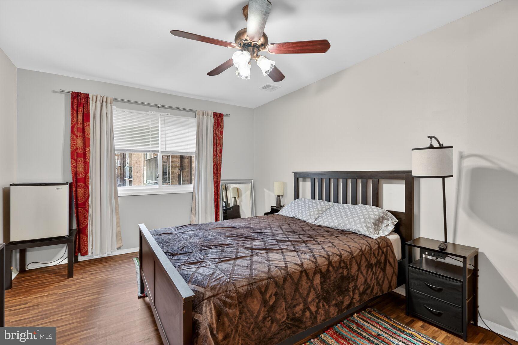 3850 Bel Pre Road, Unit 38504 Silver Spring, MD 20906 - Photo 5 of 15 a bedroom with a bed and wooden floor