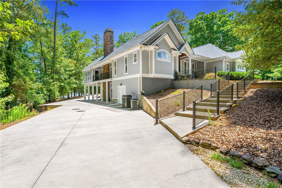 285 Bertha Allen Road Westminster, SC 29693 - Photo 45 of 50 Elegant lakeside residence with multiple balconies and a wide driveway, nestled among mature trees.