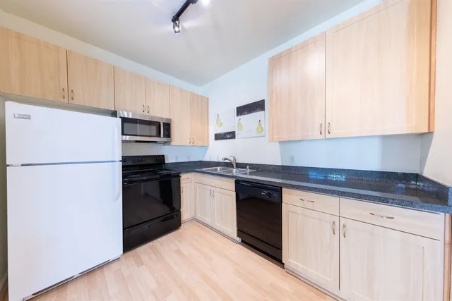 a kitchen with a refrigerator stove and white cabinets