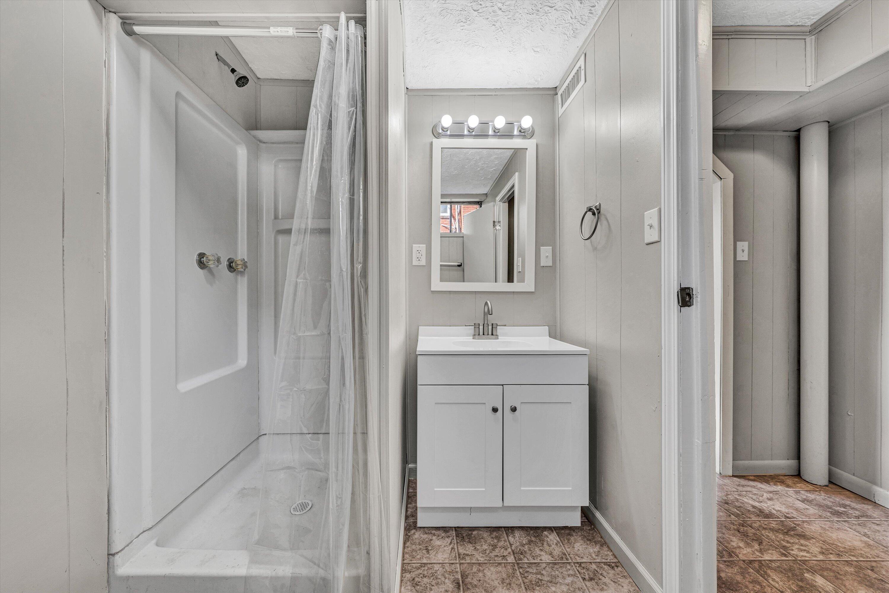 5225 Florist Road Roanoke, VA 24012 - Photo 25 of 38 a bathroom with a sink a mirror a vanity and a shower