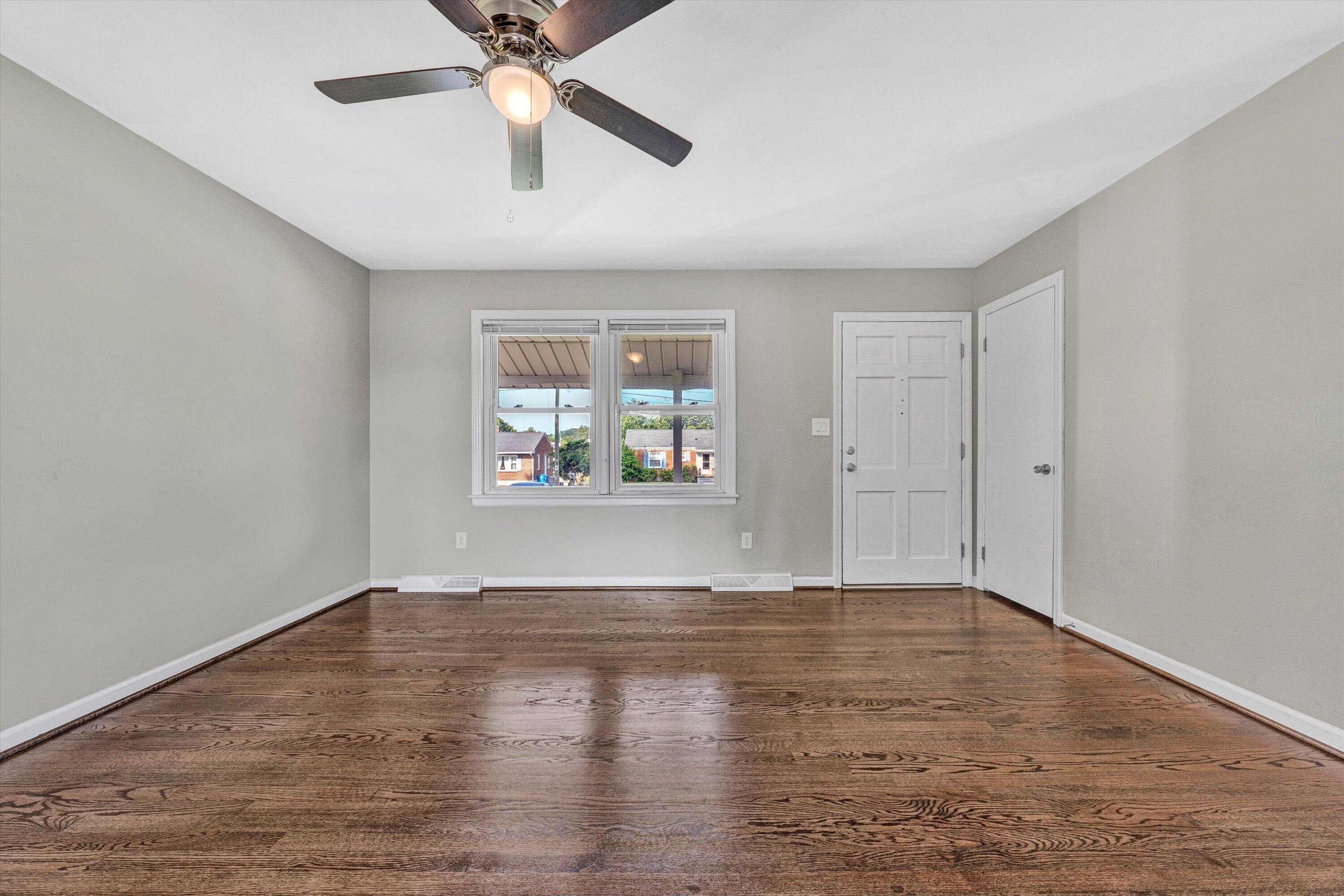 5225 Florist Road Roanoke, VA 24012 - Photo 4 of 38 an empty room with wooden floor chandelier fan and windows