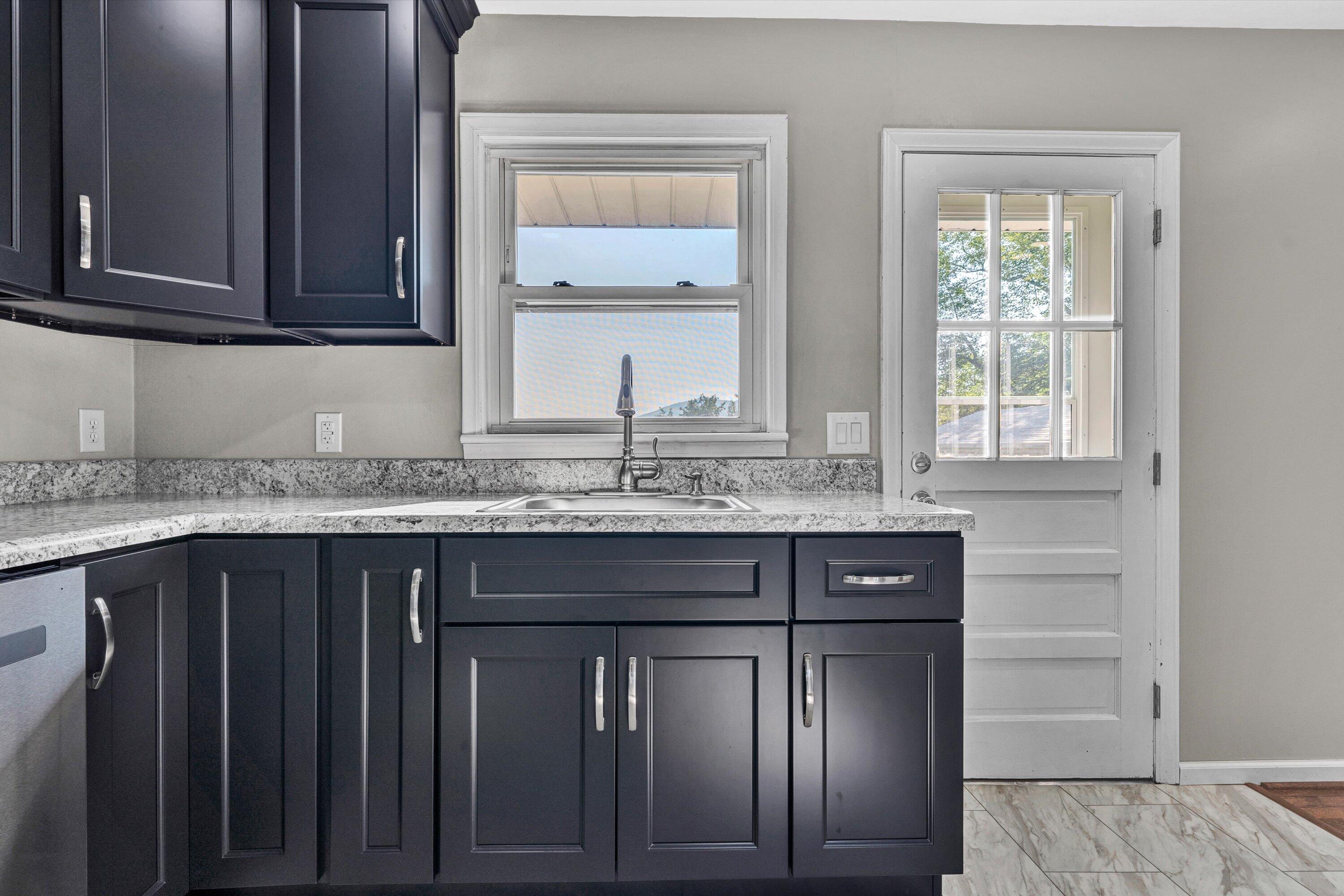 5225 Florist Road Roanoke, VA 24012 - Photo 10 of 38 a sink with granite countertop wooden cabinets