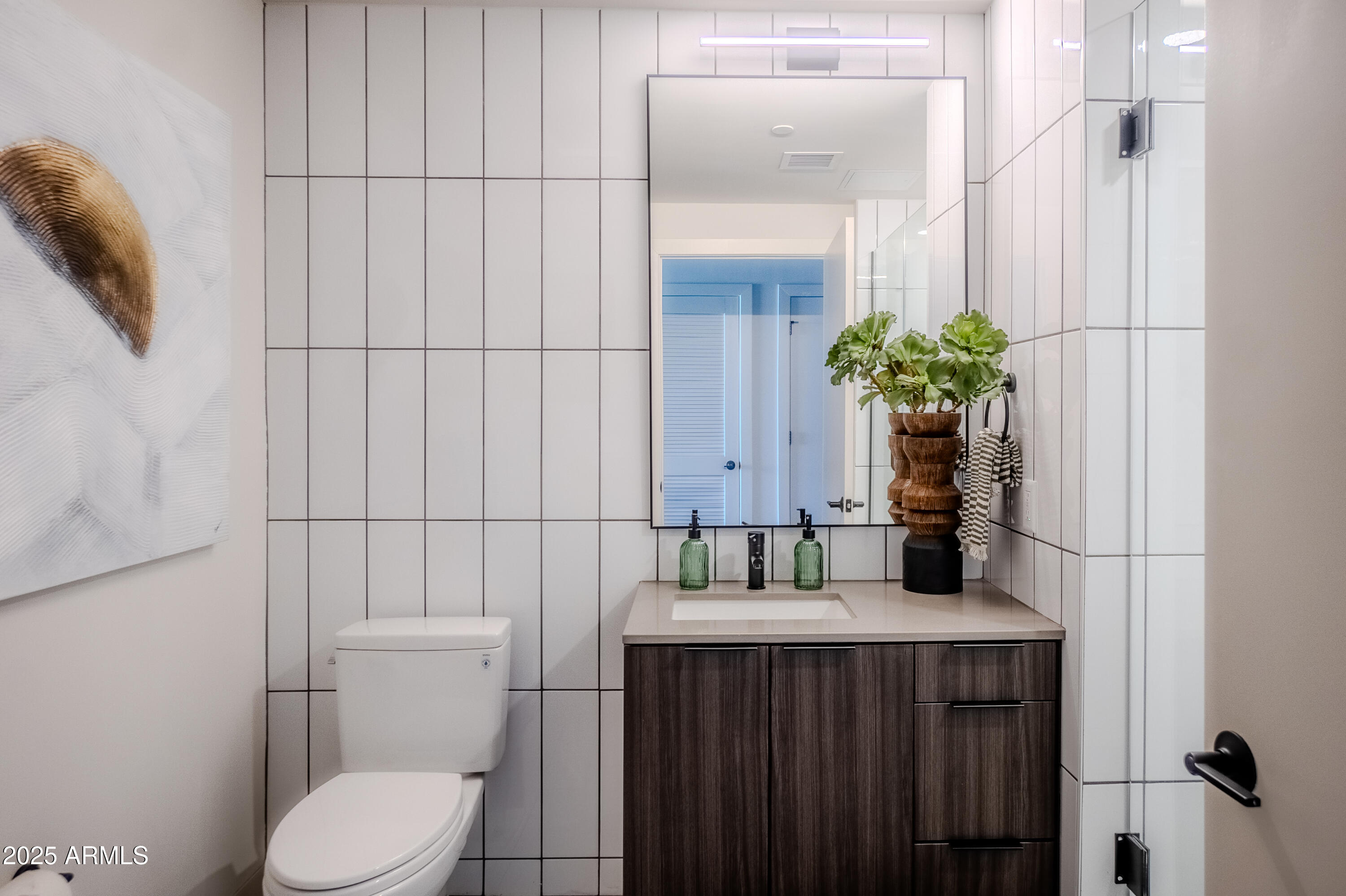 50 East Fillmore Street Phoenix, AZ 85004 - Photo 29 of 33 a bathroom with a toilet sink and mirror