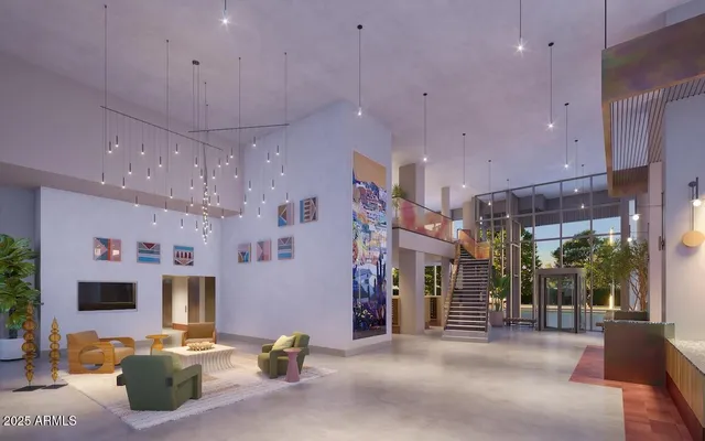 a living room with stainless steel appliances furniture a chandelier and a kitchen view