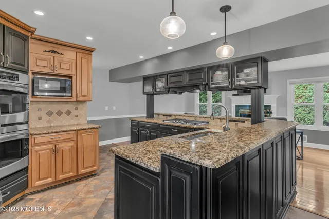 a kitchen with stainless steel appliances granite countertop a kitchen island a stove and a sink